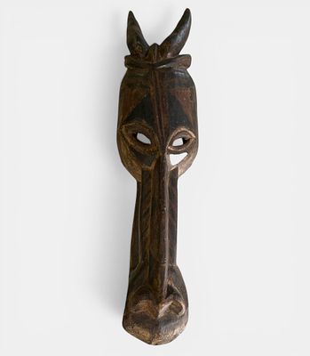 Large animal mask in polychrome wood with stylized bovid head. Large animal mask carved from 