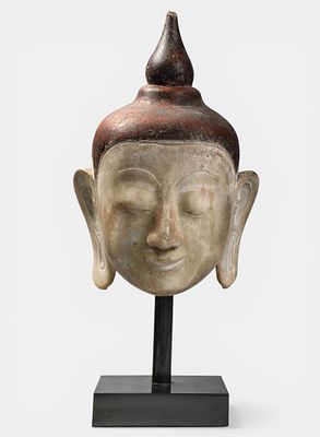 Buddha head of youthful beauty and serene expression with ushnisha and rasmi. Beige sandstone 