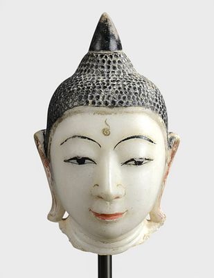 Buddha's head marked by the urn in the center of the forehead. With curly hair topped by a 