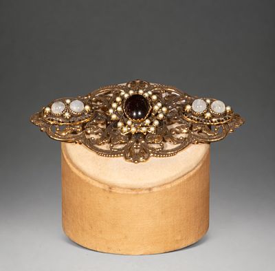 Gilded silver brooch with garnets and pearls. A gilt silver brooch in a historicist style with 