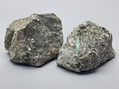 Pair of Natural Raw Emerald Stones. A pair of natural raw emerald stones, composed of dark 
