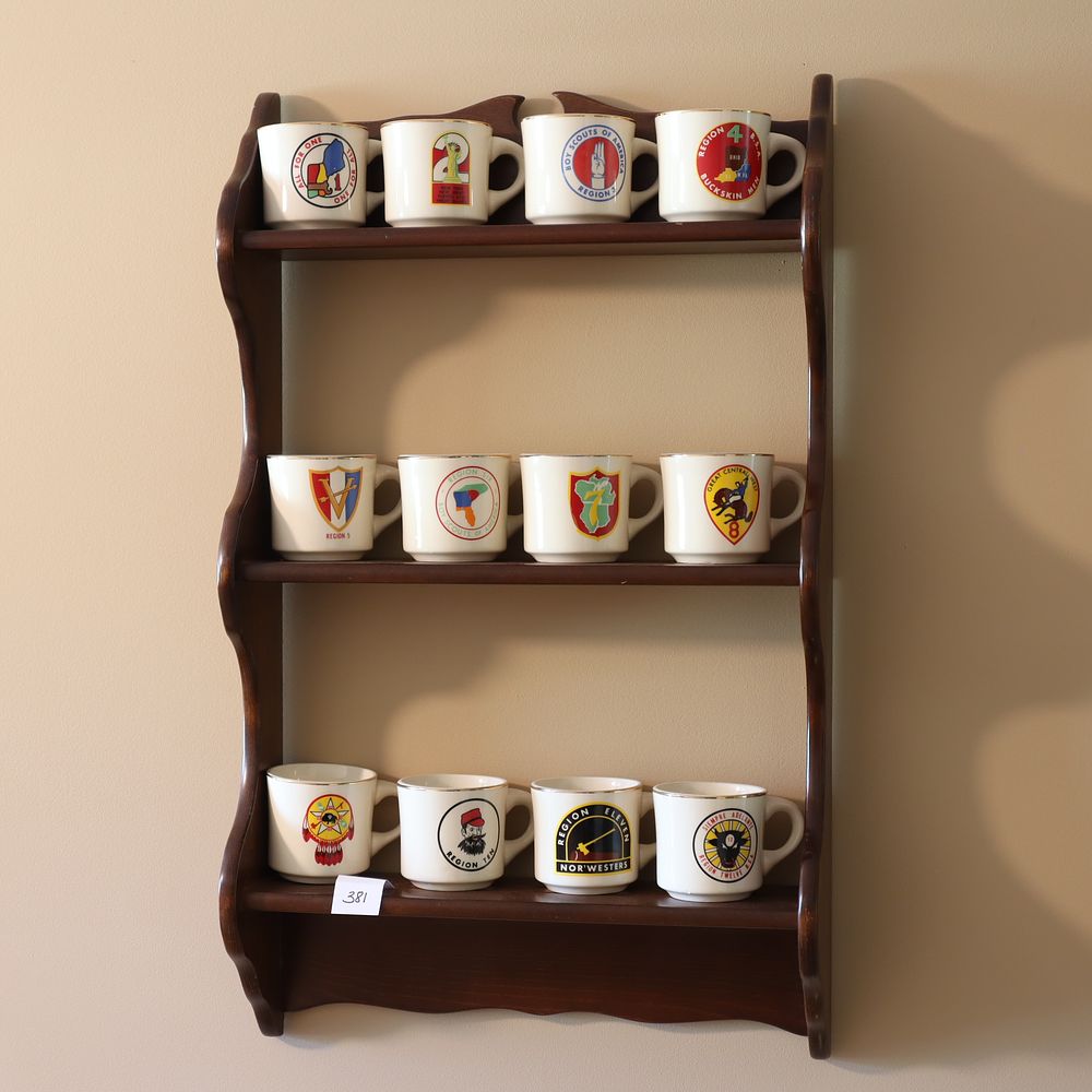 Lot 381: Vintage Boy Scout mugs with the display oak shelf