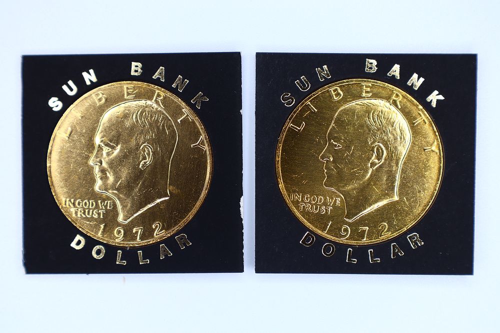 Lot 167: A Pair of Gold-Plated 1972 US Eisenhower Dollars in Sun Bank Mounts