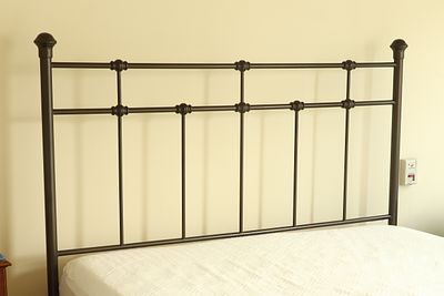 Traditional Metal Headboard in Antique Bronze Finish. A traditional metal headboard featuring a 