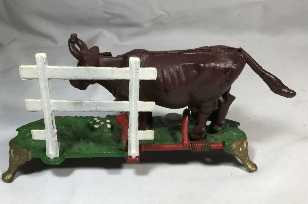 Lot 180: Mechanical cast iron milking the cow bank, height is 5 inches length 10 inches depth 3