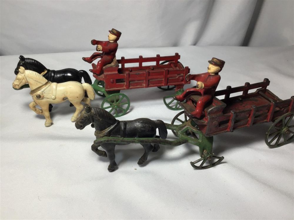 Lot 179: Early Metal Horse Pulling Wagon Toys Each measures 11 inches long  Wheels are damaged