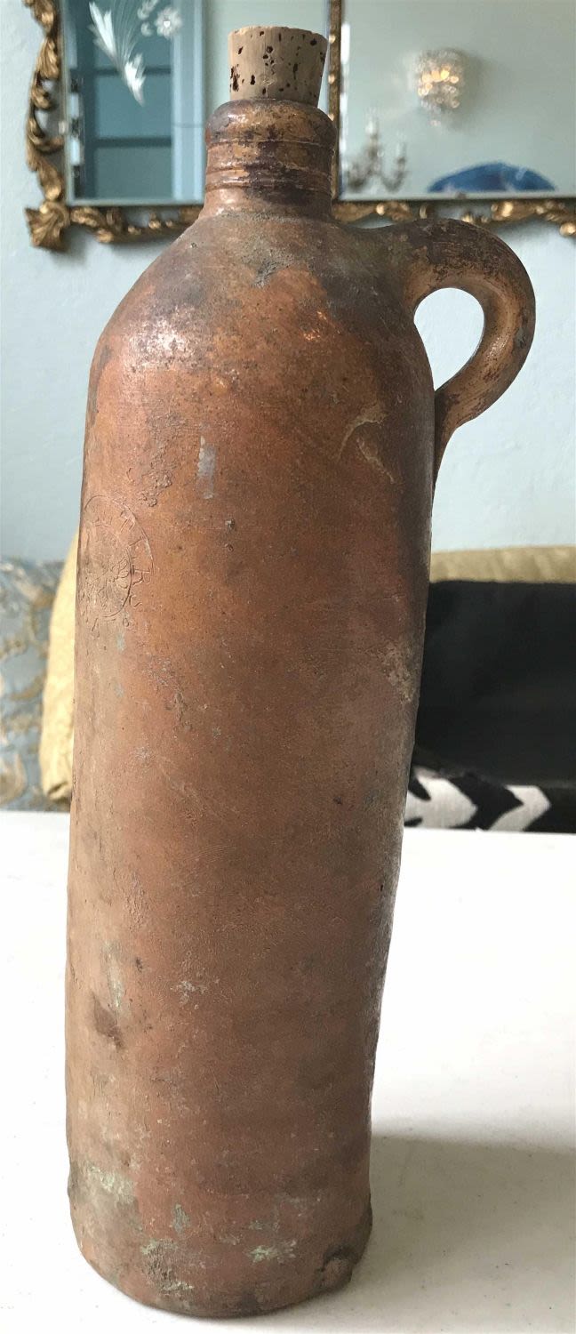 Lot 167: Vintage red clay Selters container with cork on top measures to be 12 1/2 inches tall with a 3 1/4