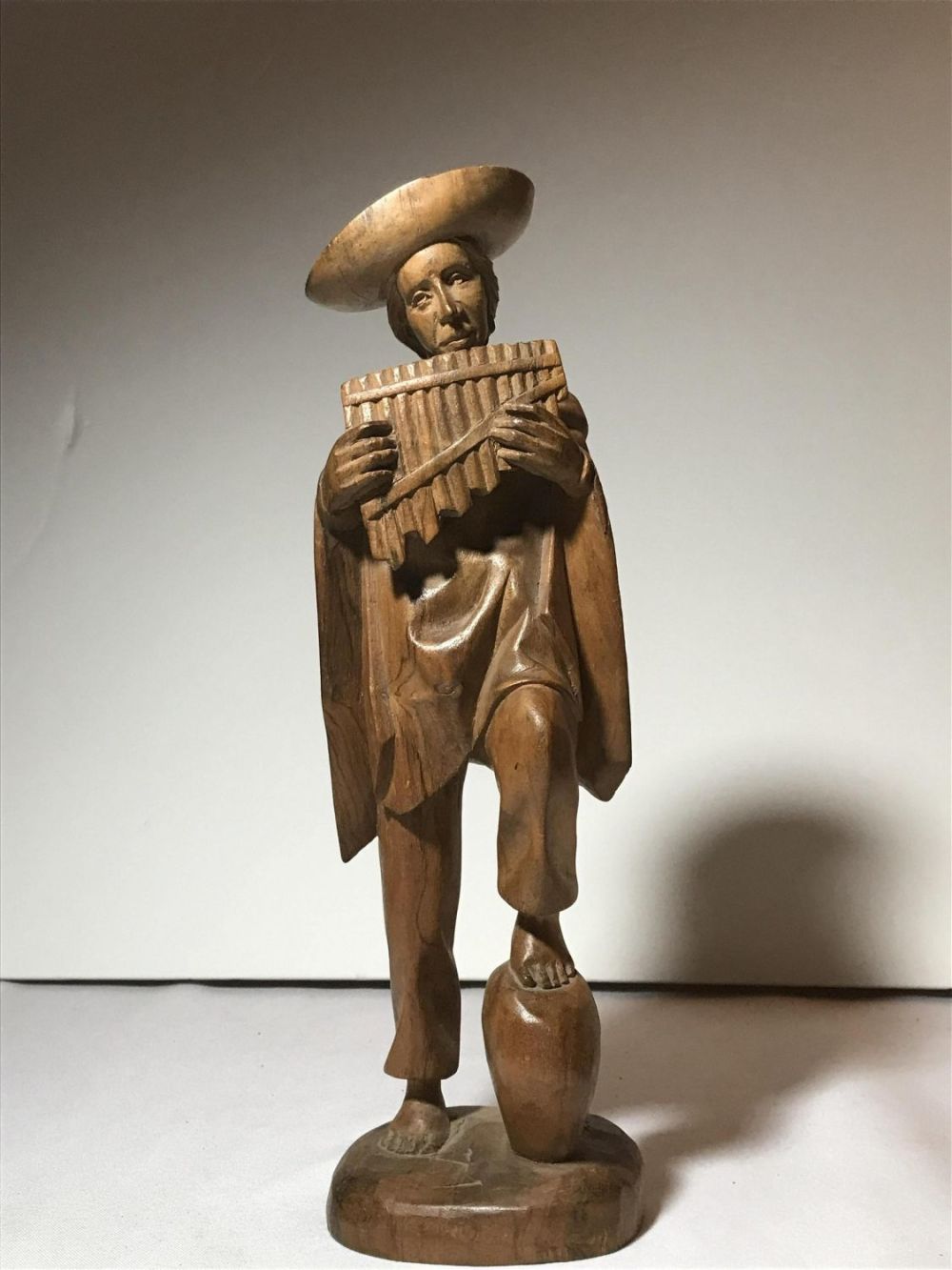 Lot 185: Vintage decorative figurine of a man playing a flute made of wood, hand carved. This piece measures