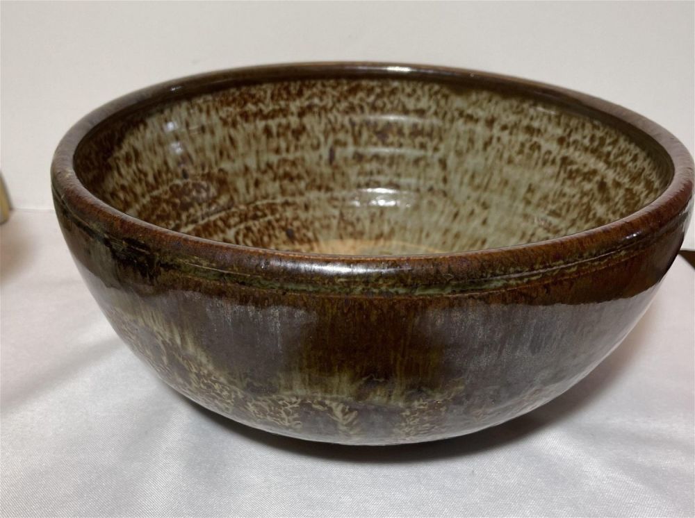 Lot 150: 1970s earth tone stoneware bowl swirl mark on bottom, This piece measures 10 3/4 x 5â€ depth