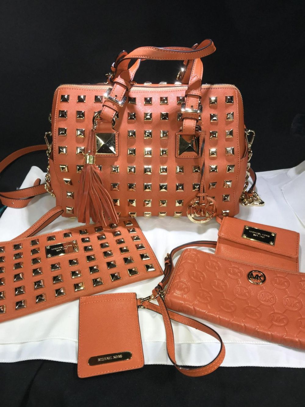 Lot 173: Michael Kors Grayson Orange/Gold Studded Satchel W/ Wallet, wristlet , coin purse & tassel