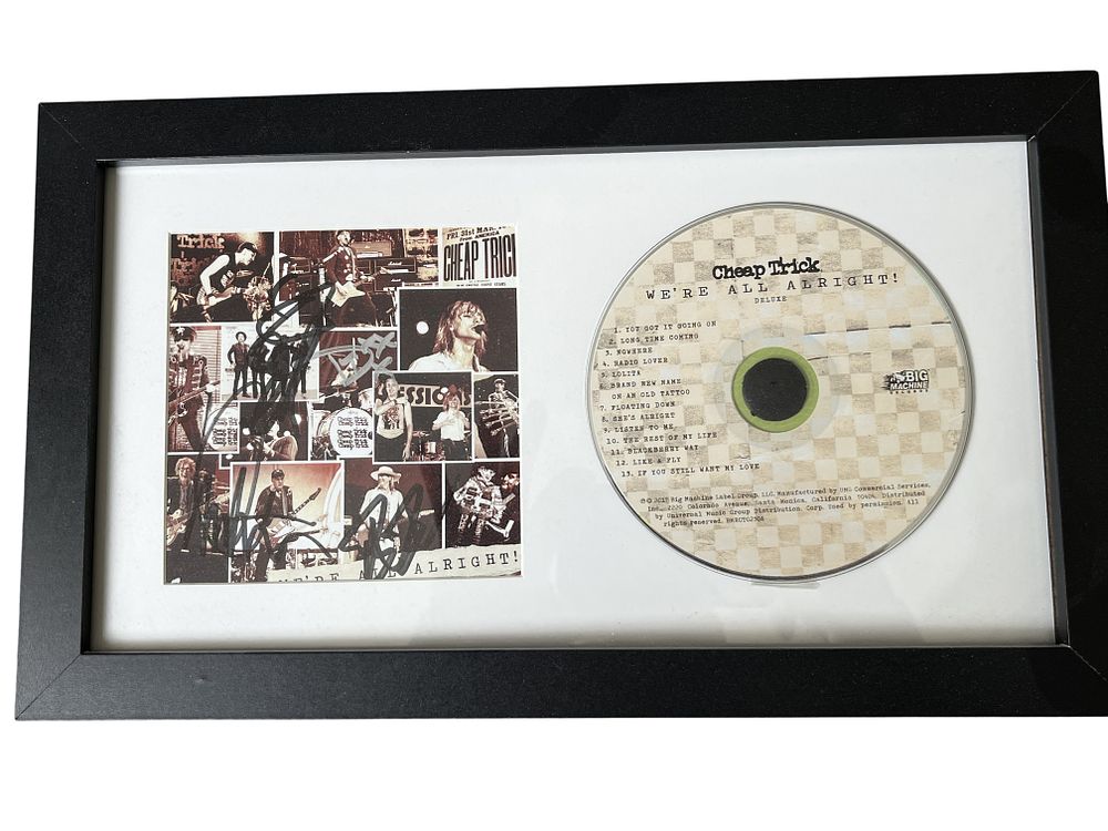 Lot 104: Cheap Trick We're All Alright! Autographed Deluxe CD and Booklet Display