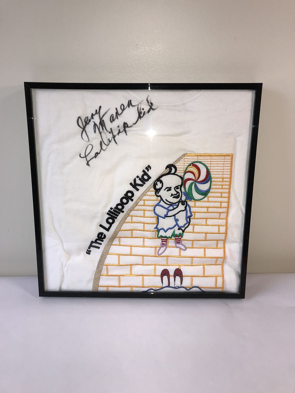 Lot 130: Jerry Maren Signed The Wizard of Oz The Lollipop Kid Framed Embroidered T-Shirt