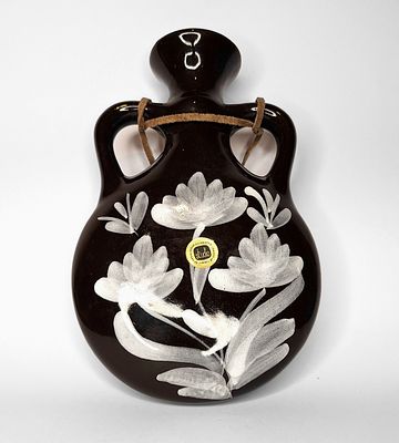 קרנת - קרנת. אגרטל קרמיקה ישראלית תוצרת קרנת, כולל חוט לתלייה, בעל רקע שחור, איורי פרחים לבנים. 