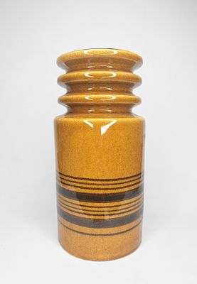 קרנת - קרנת. אגרטל קרמיקה ישראלית תוצרת קרנת, ברקע צבעי מדבר כתומים, עם עיטורים חומים סביבו. חתום