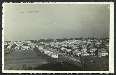 גלויה ריל פוטו של ראשון לציון וארבעה מטוסים החגים מעל היישוב, חתומה: פוטו רמברטנט, יהושע קרוטמן