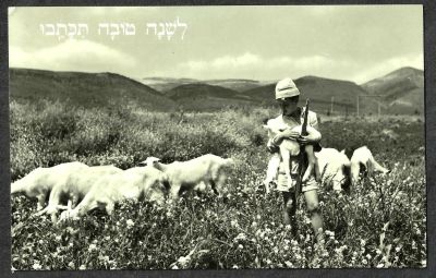 גלויה "לשנה טובה תכתבו", תמונה בשחור לבן, חלוצה מחזיקה נשק וגדי במרעה, אמסטרדם 1958