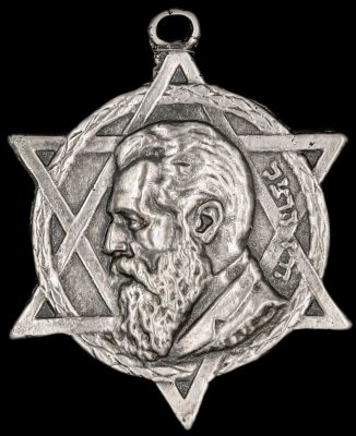 פלאק מוכסף לתלייה הנושא את דמותו של בנימין זאב הרצל בתוך מגן דוד, חריג במידותיו. מידות: 12 ס"מ * 
