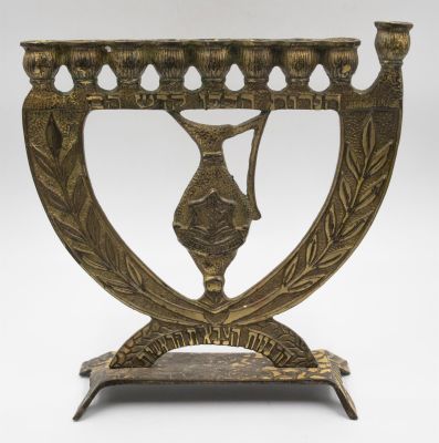 תמר - חנוכיה צה״לית עשויה ברונזה הנושאת את סמל צה״ל. כיתוב: הרבנות הצבאית הראשית. חברת תמר. גובה: 