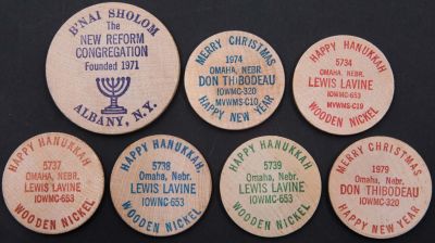 לוט הכולל 7 טוקנים יודאיקה אמריקאים עשויים עץ, שונים זה מזה. הטוקנים הם מסוג wooden nickel 