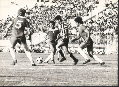 בני טבק - תצלום של חלוץ מכבי תל אביב, בני טבק, מוקף בשחקני הפועל ירושלים, מאי 1976. תצלום חתום: 