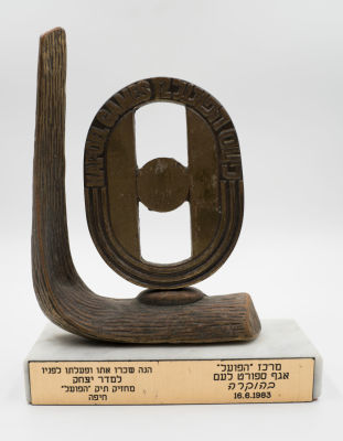 כינוס הפועל ה-12: פסל ברונזה של סמל הכינוס על בסיס שיש, כולל הקדשה ממרכז הפועל. גובה: 17 ס"מ