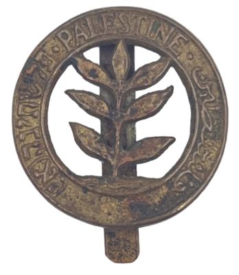 סמל כובע של הרג'ימנט הארצישראלי, תקופת המנדט. כיתוב Palestine - פלשתינה (א"י) באנגלית, עברית וערבית