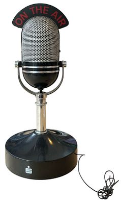 רדיו בצורת מיקרופון, כיתוב באנגלית: ON THE AIR. נדלק. גובה: 25 ס"מ