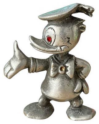 דונאלד דאק - פסלון מתכת של דונאלד דאק, לא חתום, שני אבנים אדומות נשרו (מעין אחת ומהפפיון). גובה: 10 ס"מ
