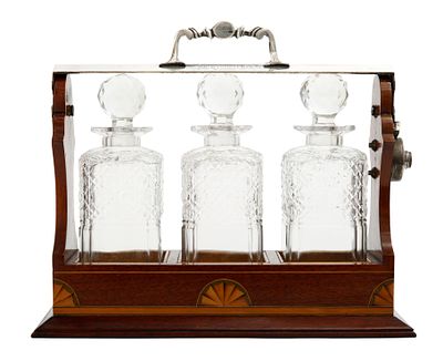 TANTALUS - ENGLISH DECANTER SET. Early 20th century, comprising three crystal decanters set in a 