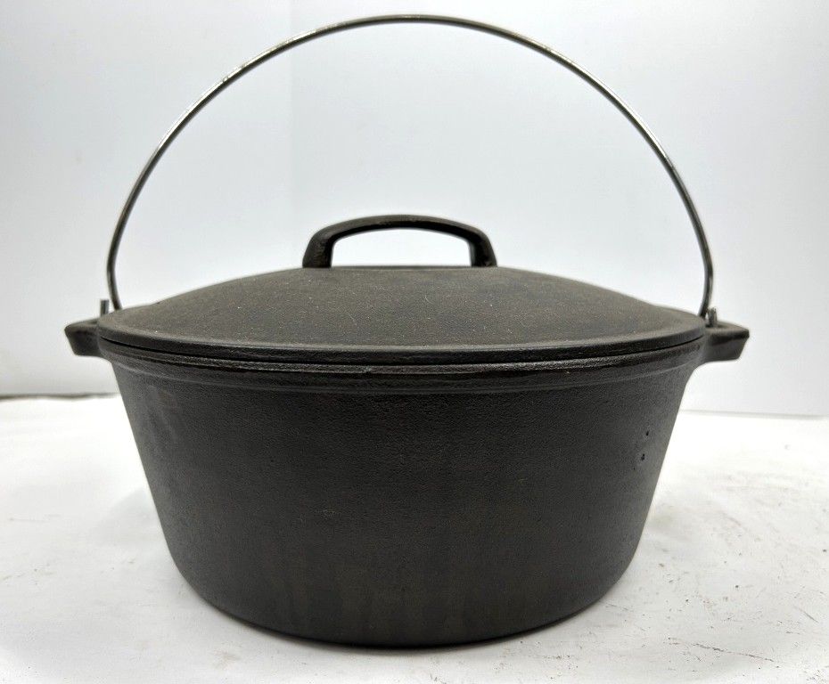 CAST IRON DUTCH OVEN. UNMARKED CAST IRON DUTCH OVEN WITH HANDLE