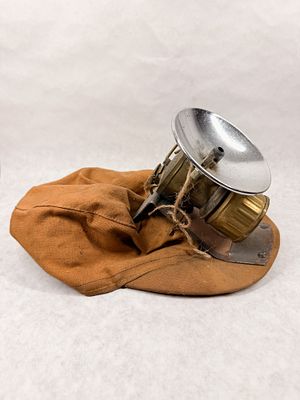 MINER CAP AND CARBIDE LAMP. A vintage tan canvas mining cap featuring a mounted brass carbide 