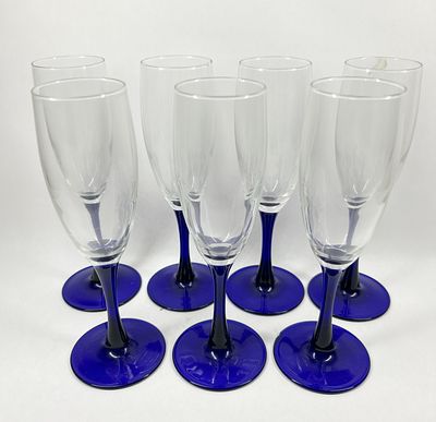 SEVEN COBALT GLASS CHAMPAGNE FLUTES. A set of seven champagne flutes featuring clear glass bowls 