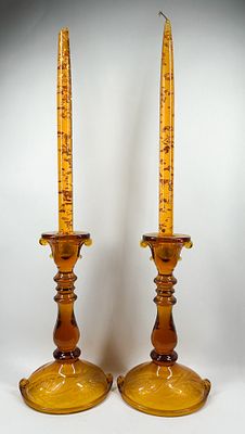 AMBER GLASS CANDLESTICKS AND OIL CANDLES, MID-CENTURY. A pair of amber glass candlesticks 