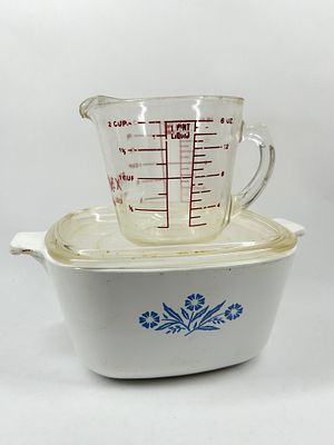 PYREX AND CW FLORAL KITCHENWARE. A clear glass two-cup measuring cup featuring a red printed 