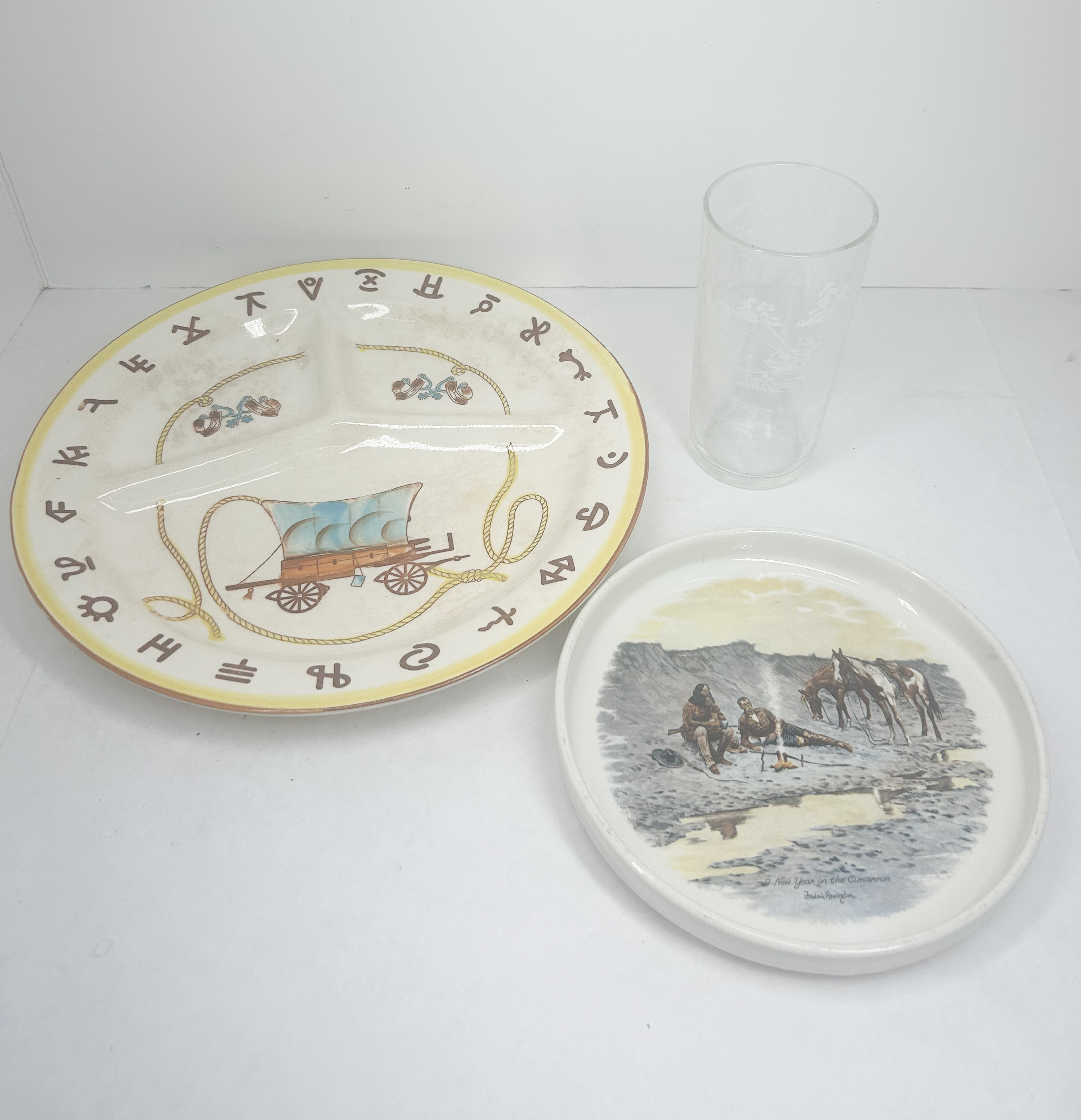 A TRIO OF CERAMIC AND GLASS WESTERN-THEMED TABLETOP ITEMS INCLUDING A FREDERIC REMINGTON PRINT DECORATED PLATE