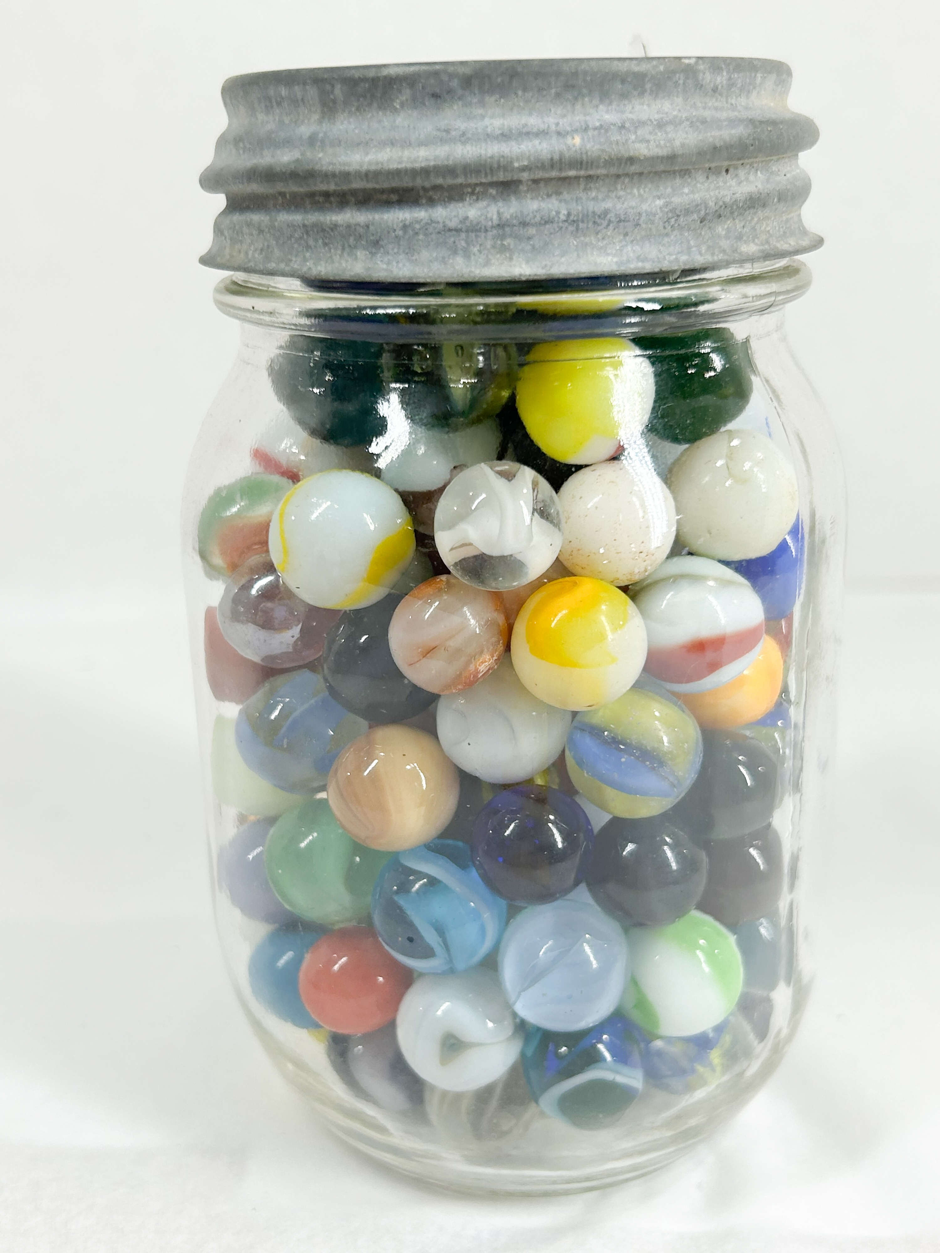 ASSORTED GLASS MARBLES IN MASON JAR