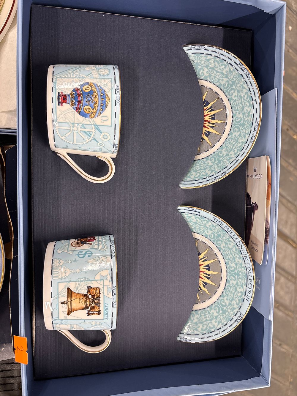 A Pair of Wedgwood Millennium Collection Mugs and a Pair of Crescent-Shaped Plates, crafted 