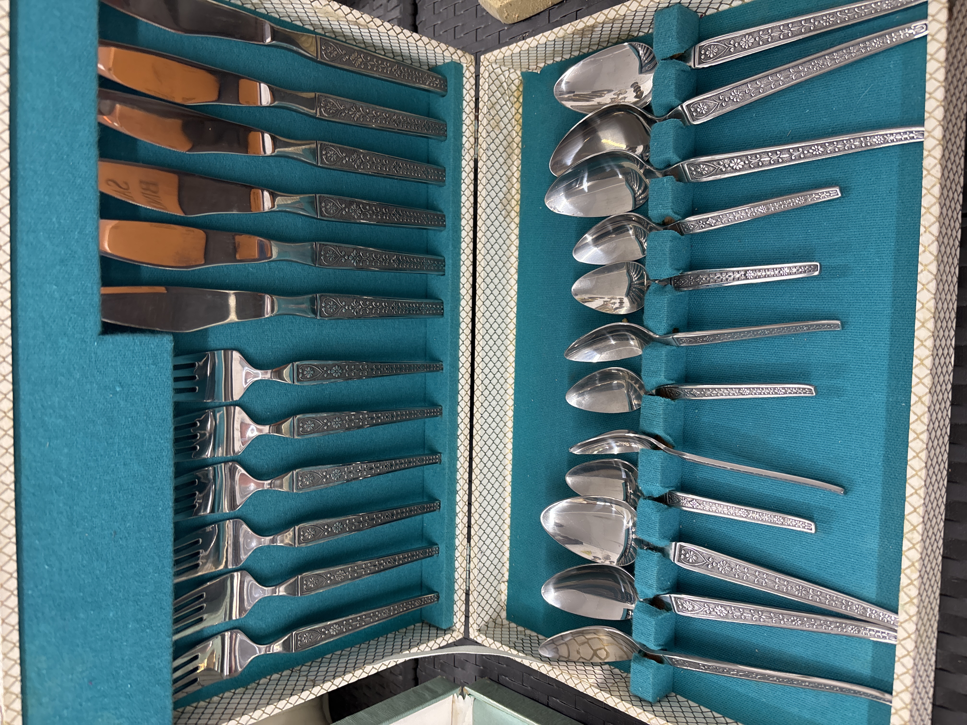 A Twenty-Four Piece Stainless Steel Flatware Set with Floral Pattern in Canteen