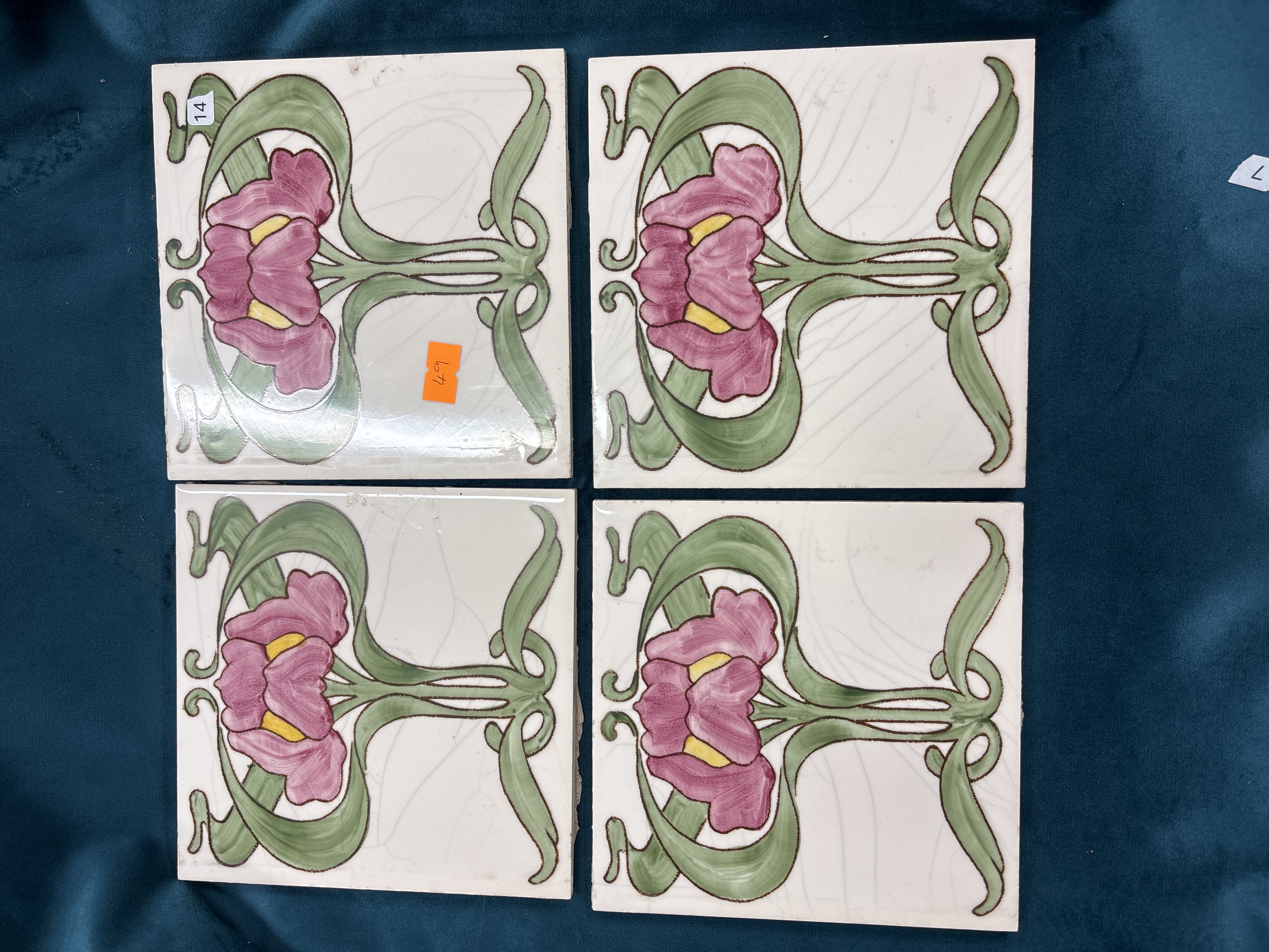 A set of four matching Art Nouveau floral decorated ceramic tiles