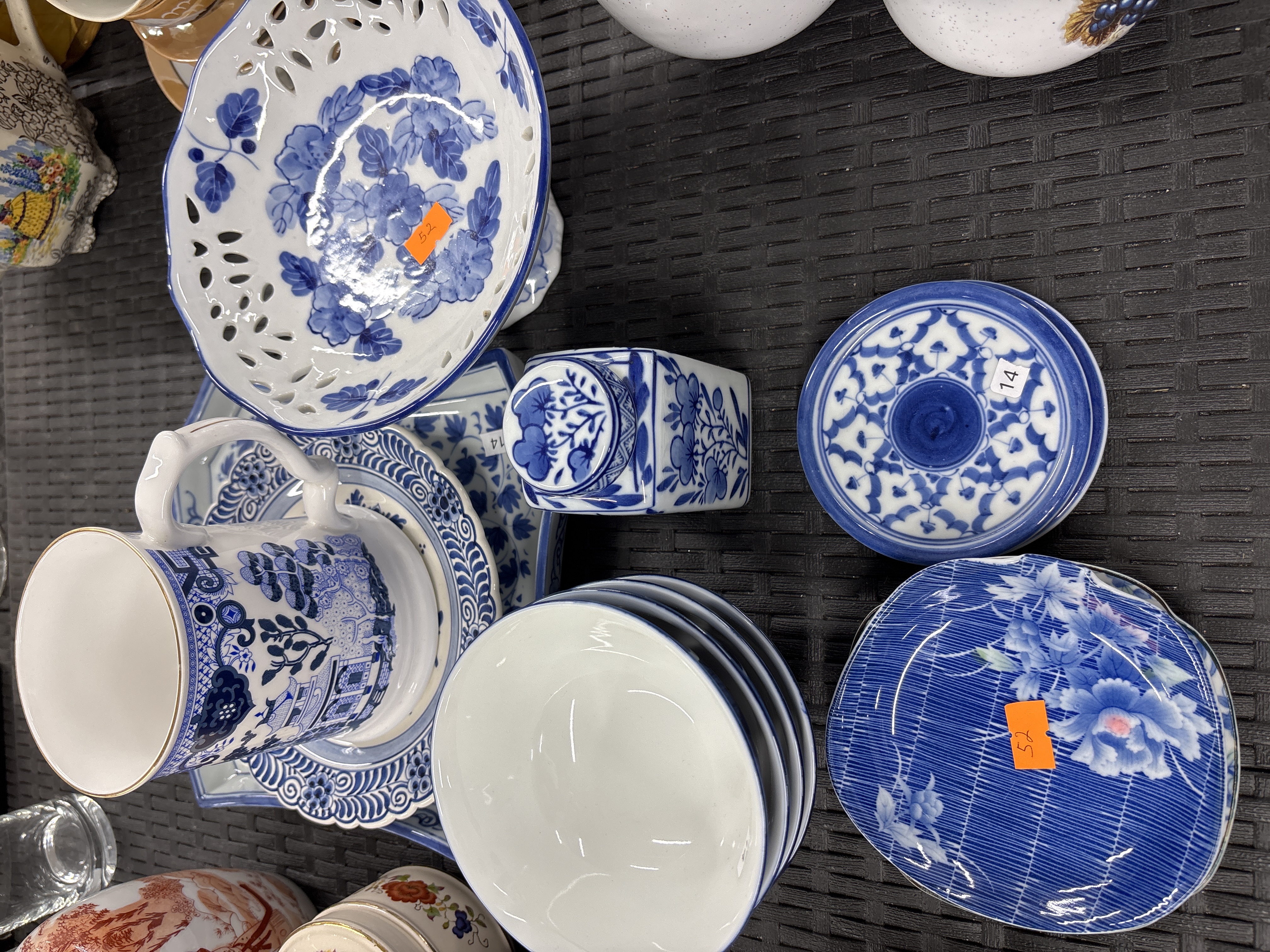 A collection of blue and white ceramics including a reticulated bowl and Willow pattern mug