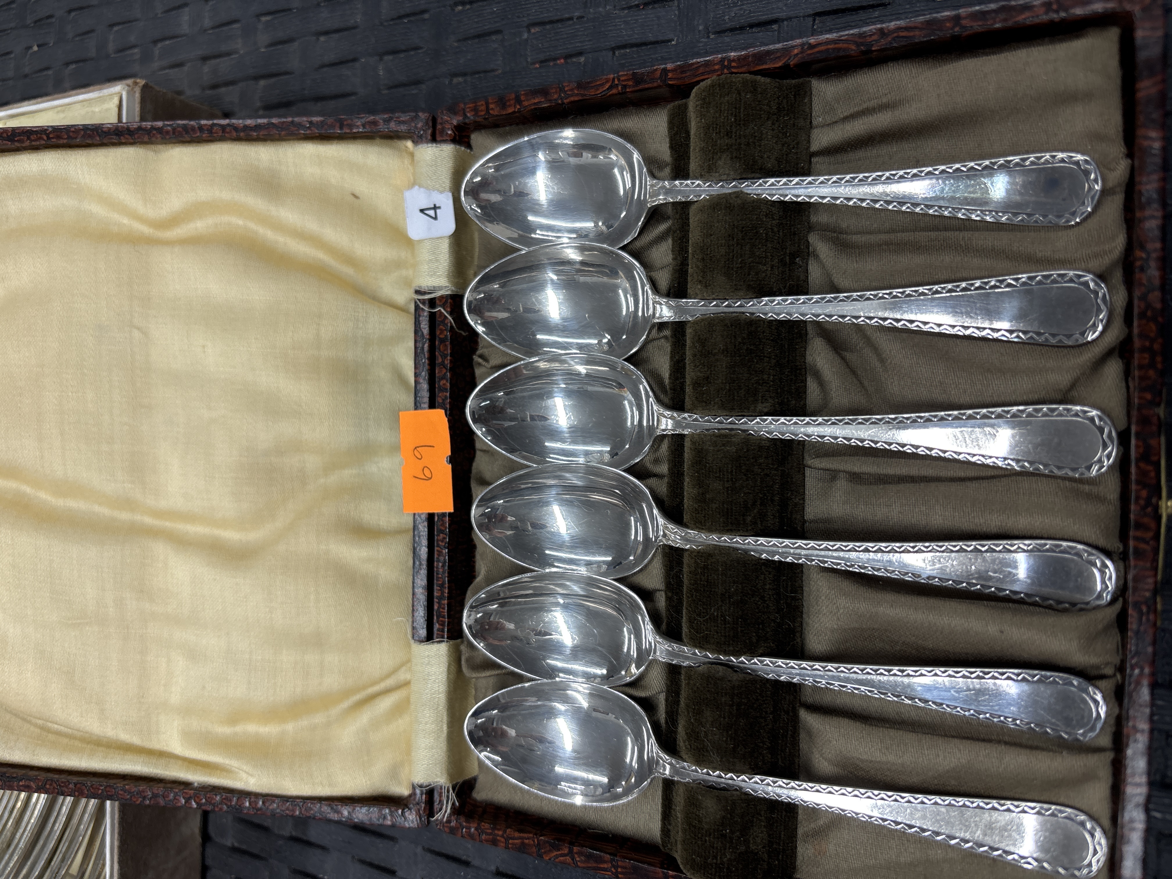 A Set of silver-toned teaspoons with bright-cut decoration in a fitted case