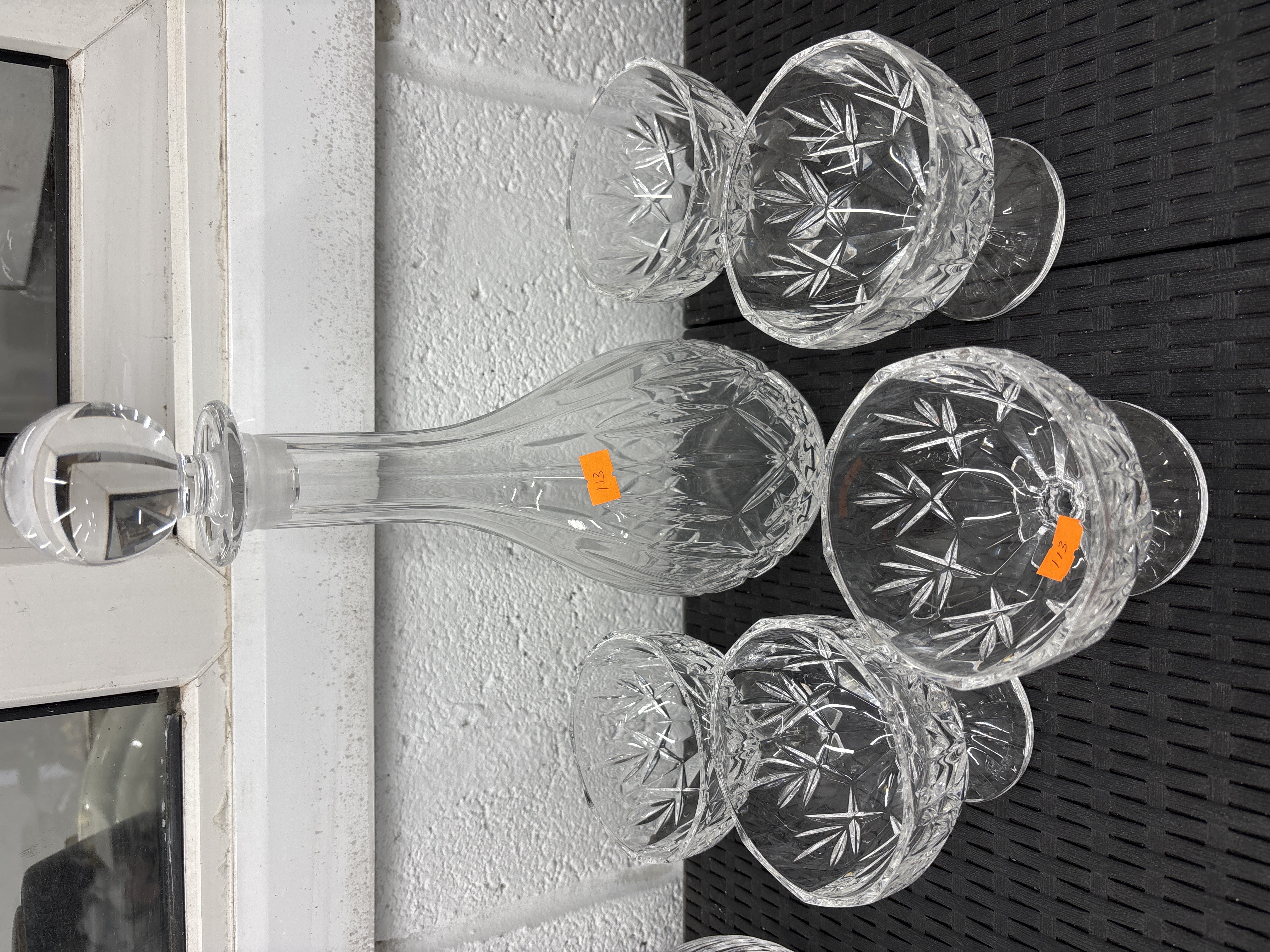 A set of cut crystal glassware including a decanter and four matching glasses