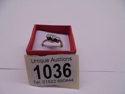 An 18ct gold three stone crossover diamond ring, size N. 3 grams.
