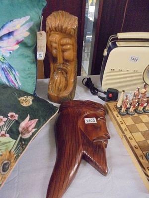 A carved wooden face of Jesus and one other carved item.