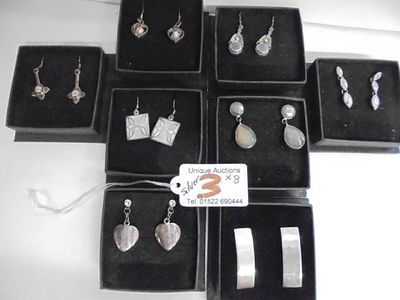 Eight pairs of silver earrings.