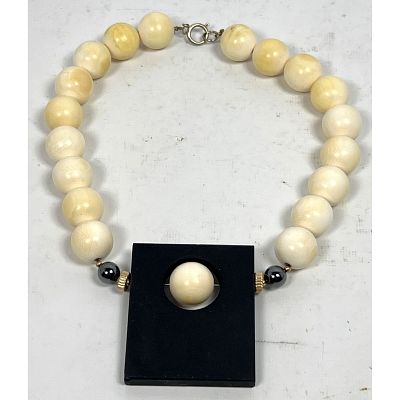 Ivory Bead Necklace with Rectangular Black Pendant. Dimensions: Height: 2.5 inches, Width: 2.25