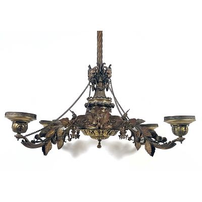 Ornate four arm chandelier executed in a neoclassical revival style. Bronze with Rams Heads. 