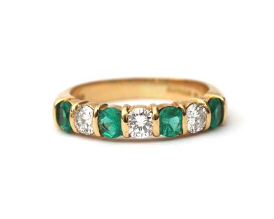 Een 18 krt. geelgouden rijring met smaragd en diamant Bezet met vier ronde gefacetteerde 