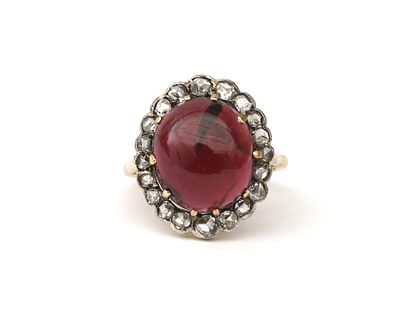 Een 14 krt. geelgouden entourage ring met een granaat van ca. 9 ct. en roosgeslepen diamant Het 