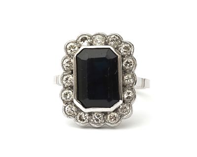 Een 14 krt. witgouden entourage ring met saffier en diamant Het middenstuk van de ring is bezet 